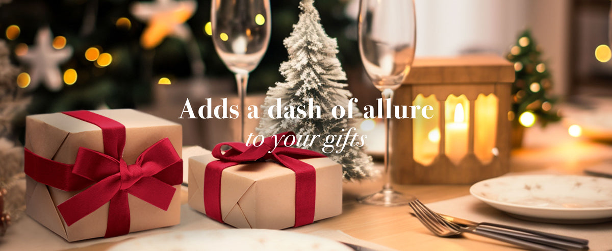 Kraft-paper gifts tied with red velvet ribbon on a warmly lit Christmas dining table.