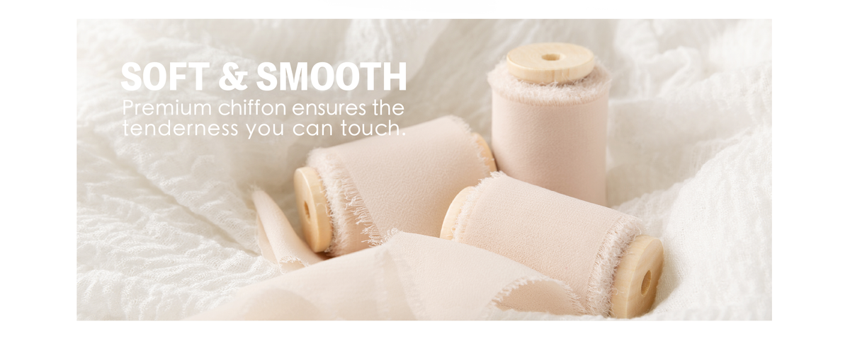 Three light nude chiffon ribbon rolls on wooden spools nestled in soft white fabric