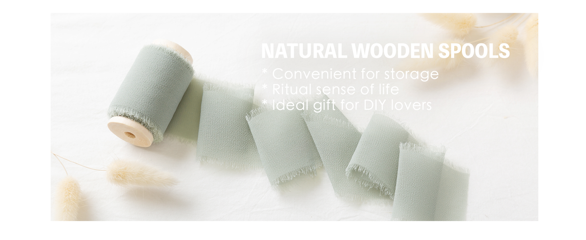 Dusty green frayed chiffon ribbon unrolled from a natural wooden spool on white fabric