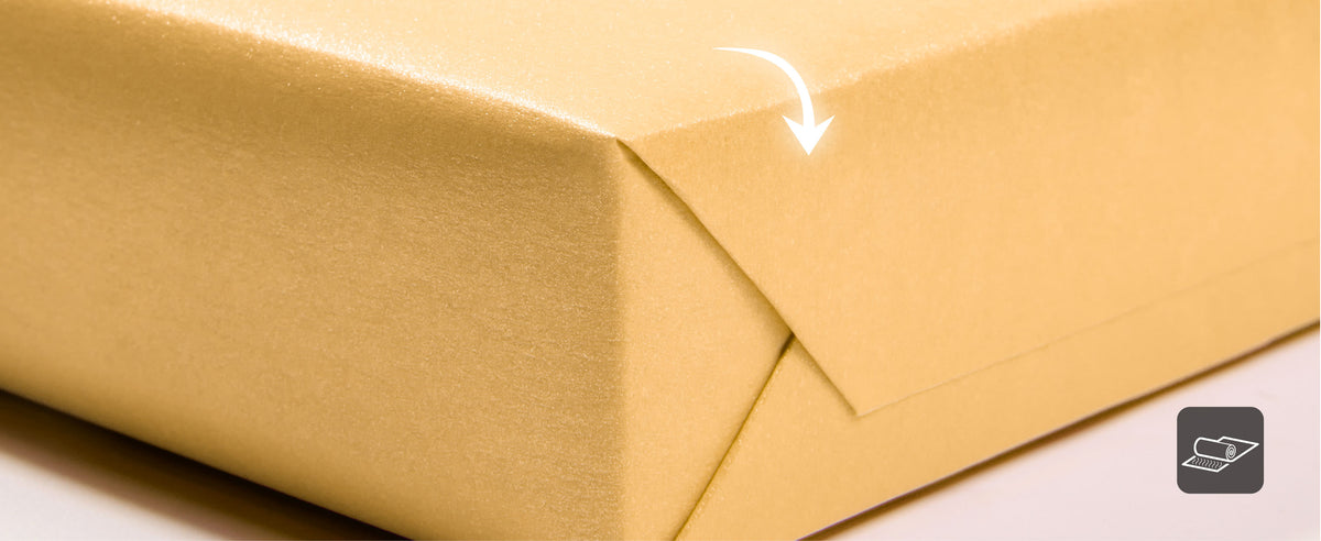 Close-up of folded gold pearly wrapping paper showing its smooth reflective finish
