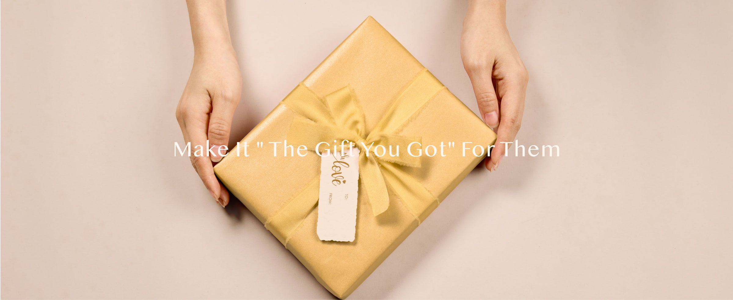 Gold gift wrapped in pearly paper with matching ribbon, tag, and decorative accents