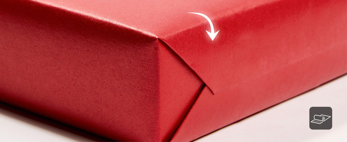Folded red wrapping paper showing a pearly outer surface and matte textured reverse