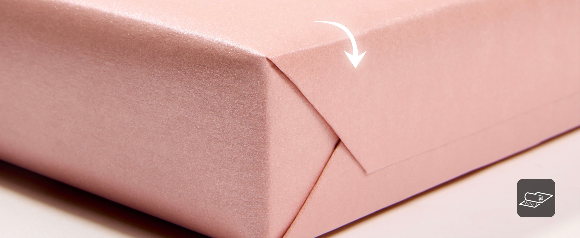 Pearly pink wrapping paper folded back to show its smooth reverse side and fine shimmer