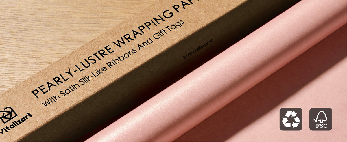 Pearly pink wrapping paper roll beside its kraft box with recycling and FSC symbols