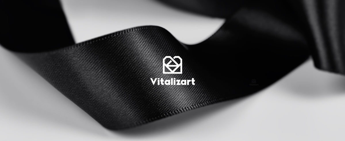 Glossy black satin ribbon in soft folds, showing its fine woven texture and finished edges.