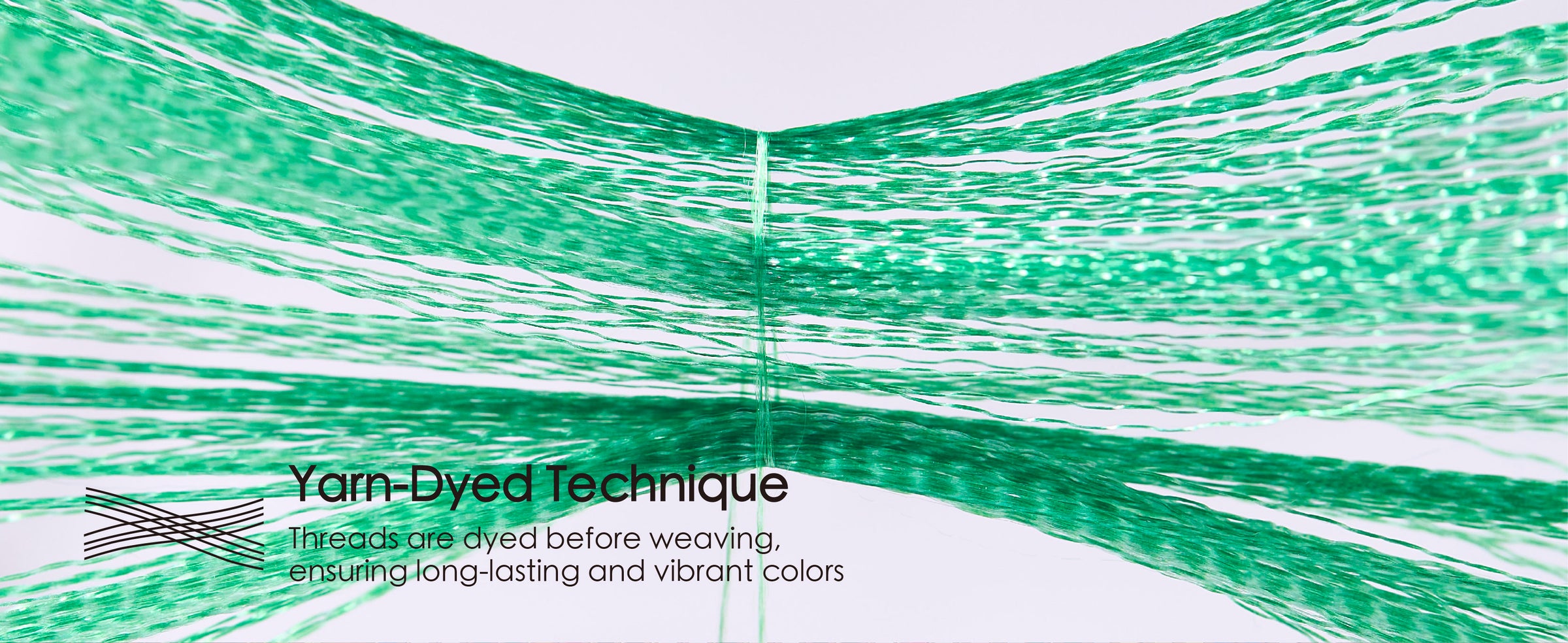 Green ribbon yarns spread apart to demonstrate the yarn-dyed construction before weaving