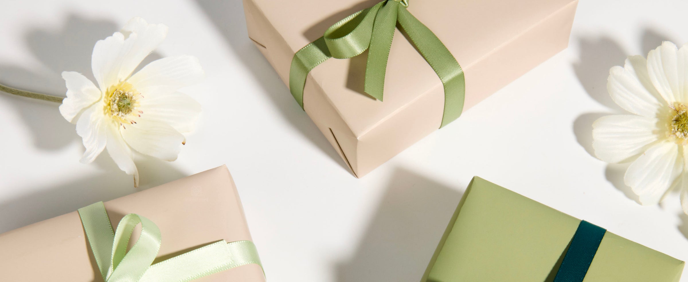 Wrapped gifts finished with layered bows made from the mint and sage double-faced satin ribbon set