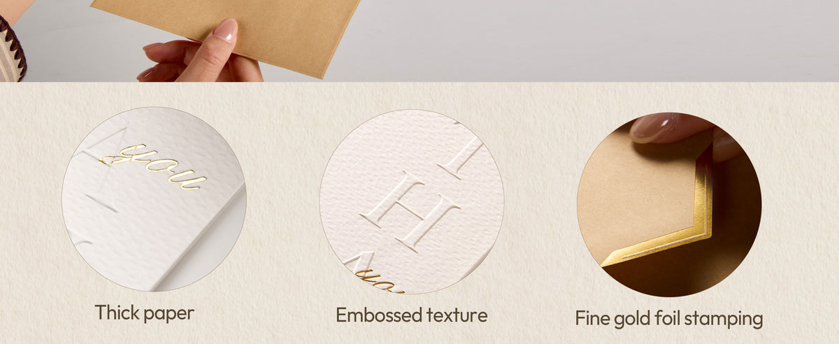 Close-up of white cards showing textured cardstock, embossed lettering, and gold foil