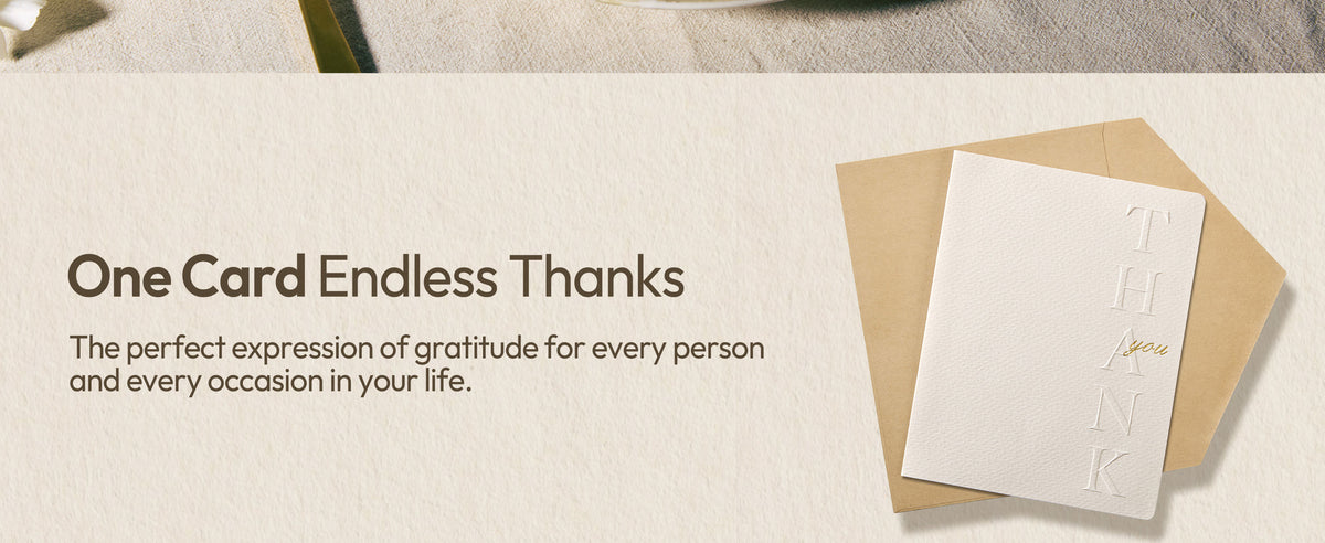 White embossed thank-you cards and matching envelopes arranged in a flat lay