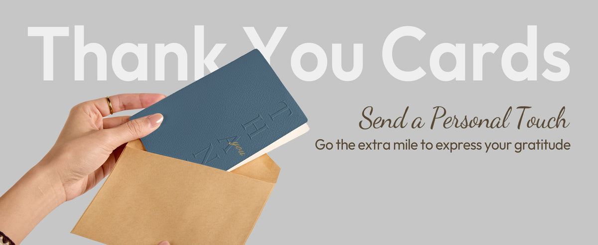 A hand holding a dusty sage embossed thank-you card with its matching envelope