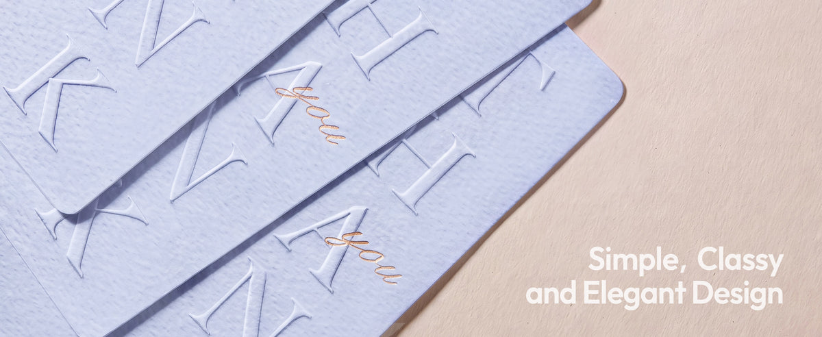 Overlapping pale blue-gray thank-you cards with pebbled texture, embossed lettering and gold script