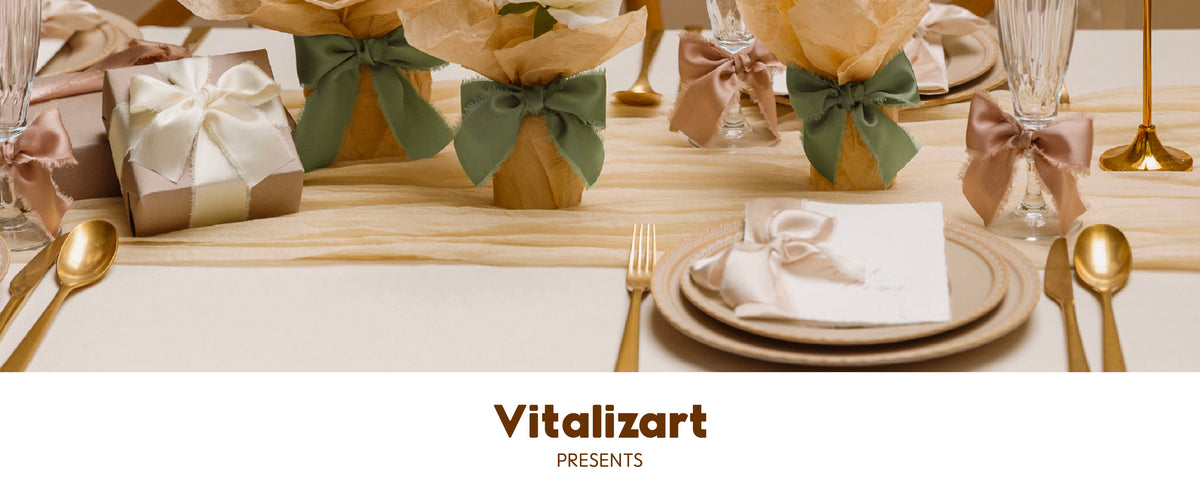 Sage, blush, and cream satin ribbon bows styling flowers, glasses, and a gift at a formal table
