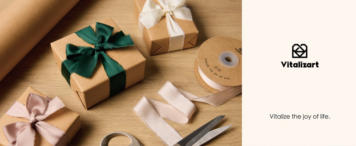 Nude frayed satin ribbon appears on a spool and gift bows alongside green and ivory ribbon on kraft boxes.