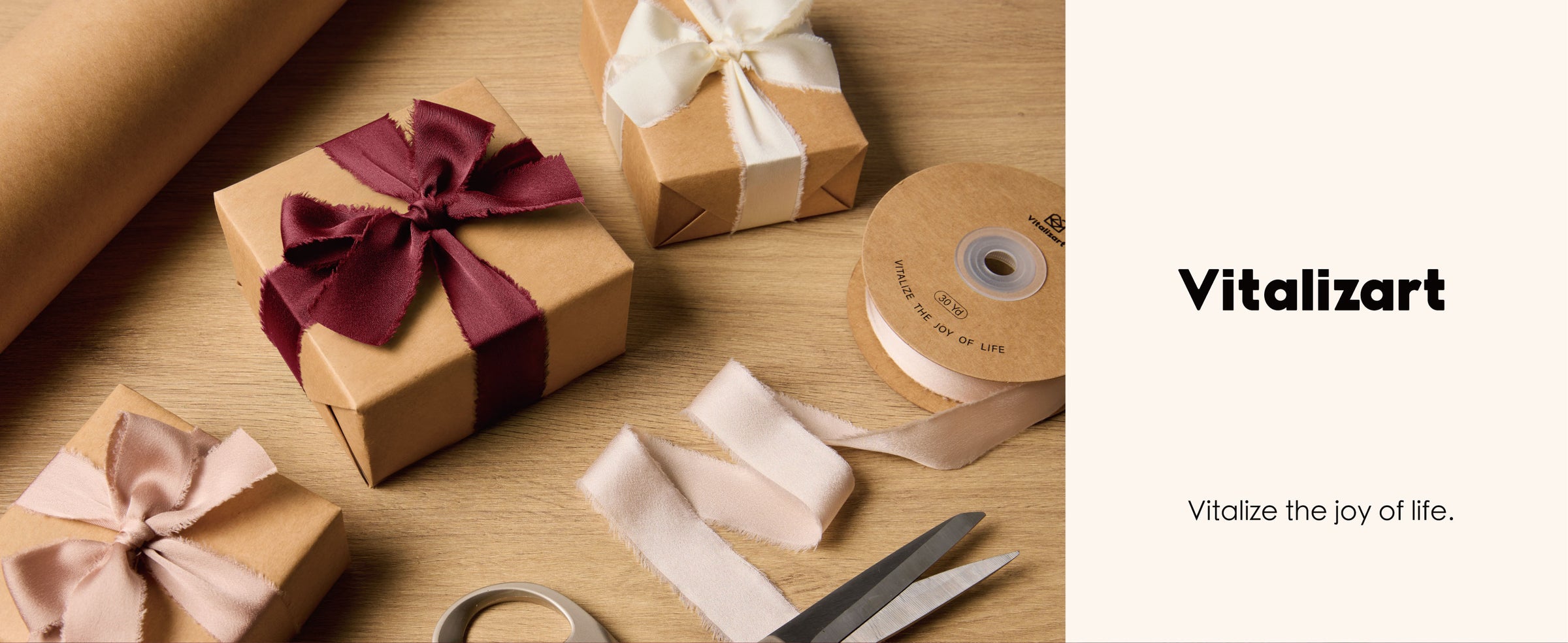 Kraft gift box tied with a burgundy frayed satin ribbon bow among wrapping supplies