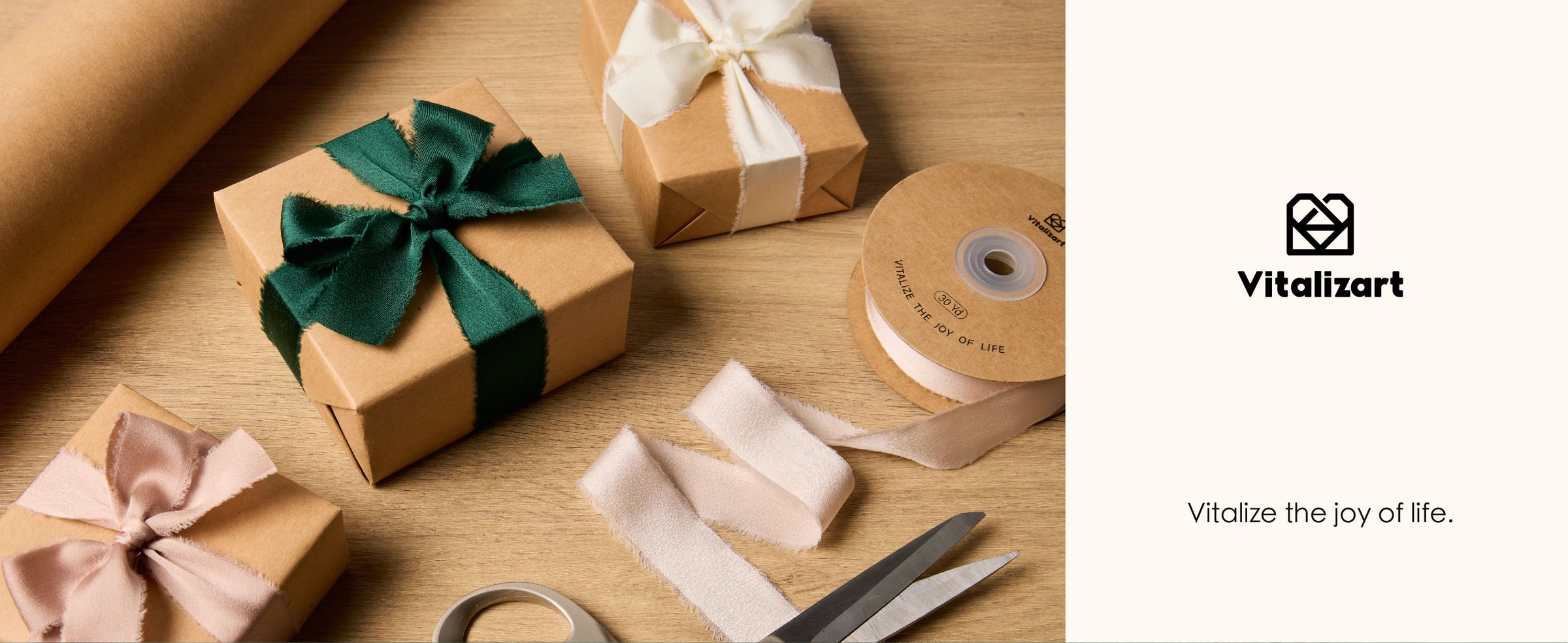 Kraft gift box tied with a dark green frayed satin ribbon bow among wrapping supplies