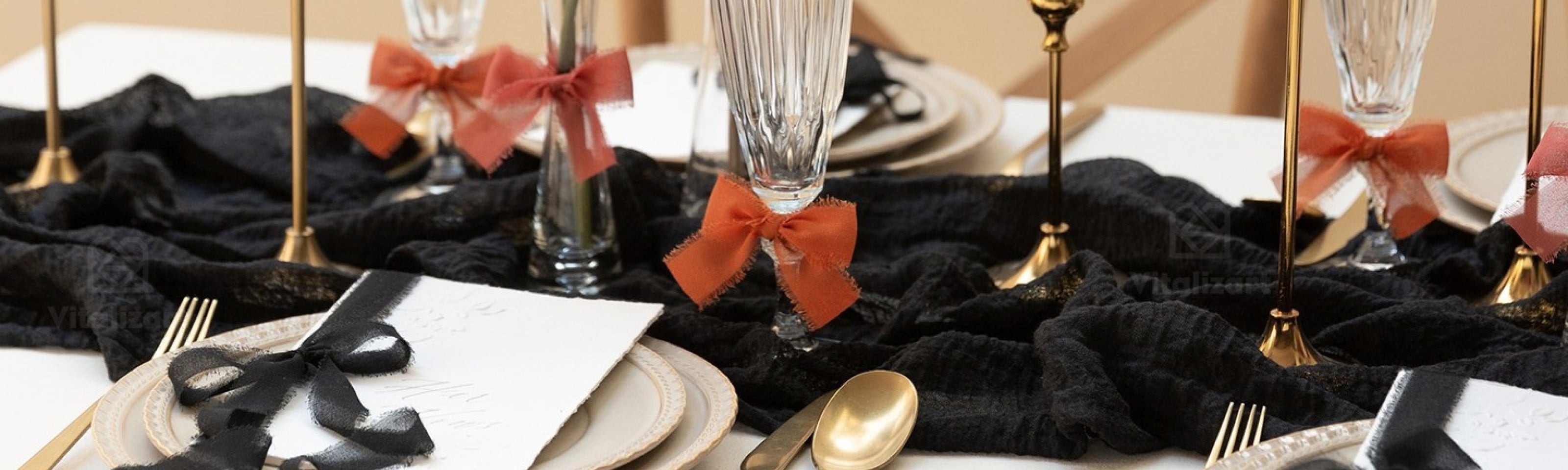 Elegant black table setting decorated with coral ribbon bows