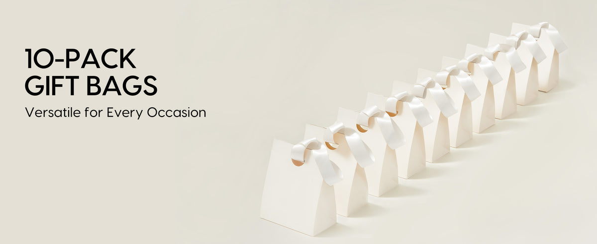 Ten white small paper gift bags with ribbon handles lined up to show the full coordinated gift bag set