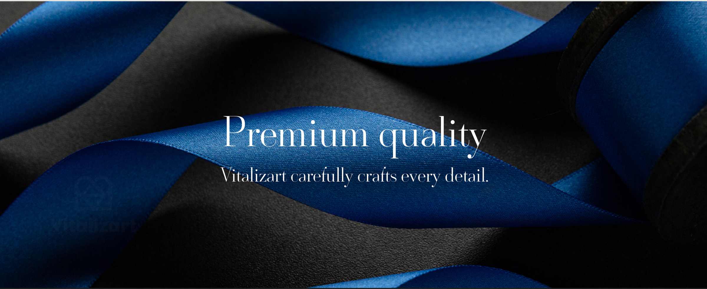 Glossy royal blue satin ribbon looping across a black textured surface beside a wooden spool.