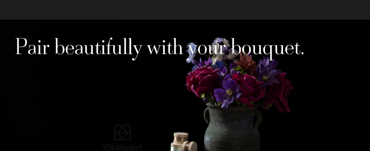 Green and purple satin ribbons decorate a vintage still life with books and a colorful flower bouquet.
