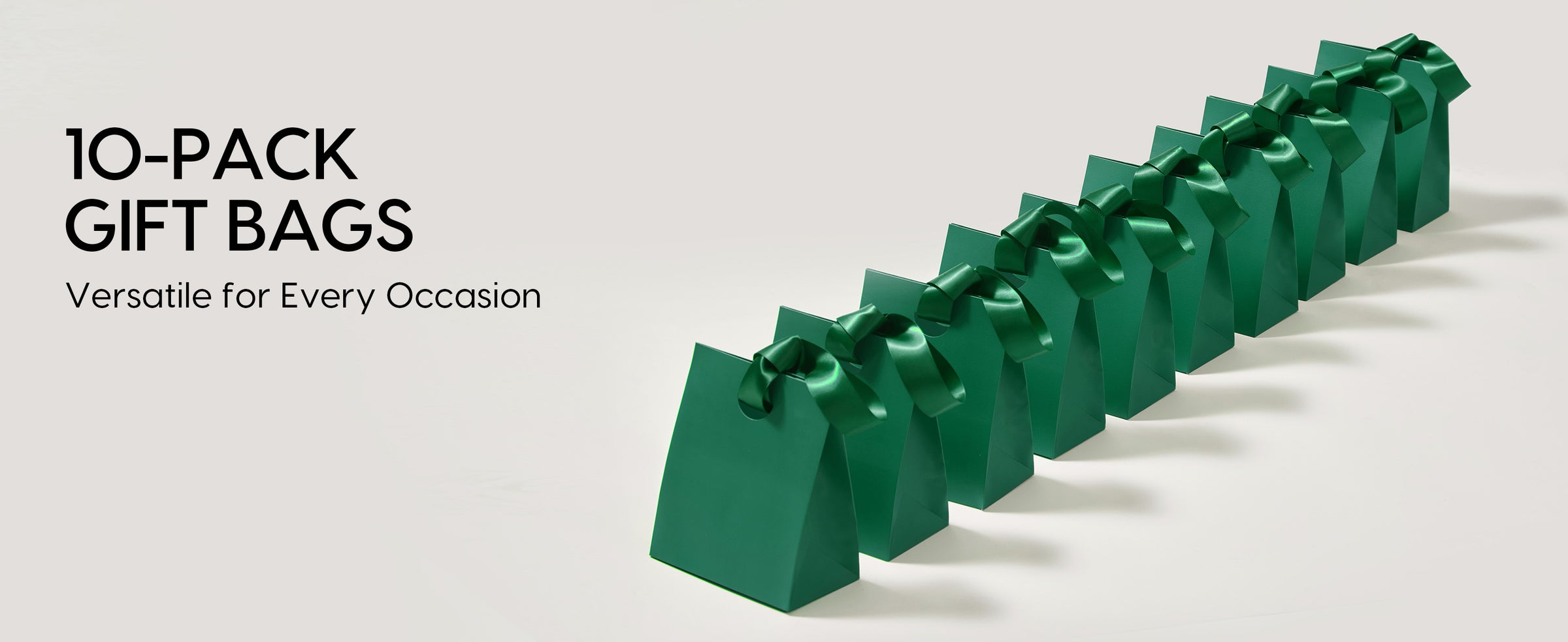 Ten dark green paper gift bags arranged in a row with glossy green satin ribbon handles