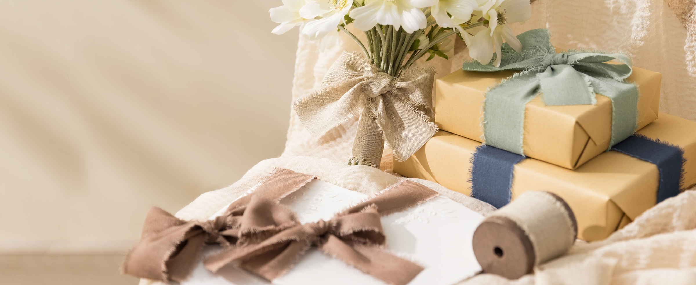 Wrapped gifts and flowers decorated with bows made from the brown cotton-linen ribbon