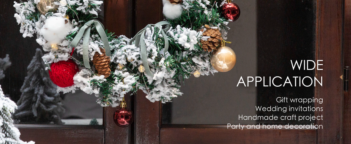 Dusty green velvet ribbon bows decorate a snowy holiday wreath with pinecones, lights, and ornaments.