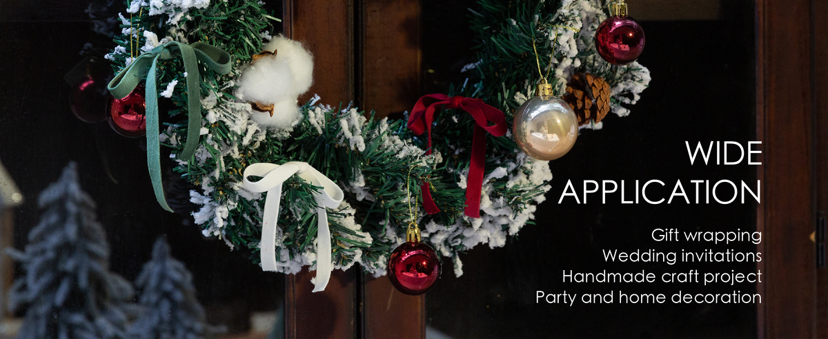 Snowy holiday wreath decorated with red, green and white velvet bows, pinecones and ornaments.