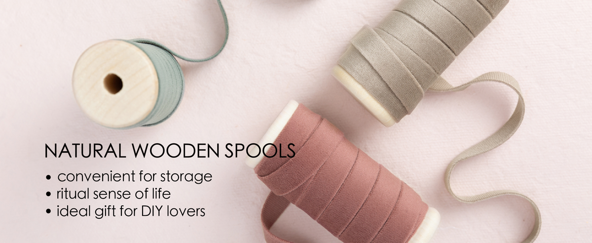 Red and green velvet ribbon set unwound from natural wooden spools in a clean product detail scene