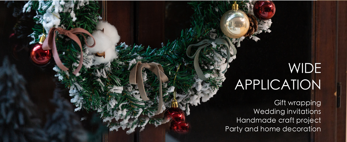 Dusty pink, sage, and brown velvet ribbon bows decorate a snowy Christmas wreath with red and gold ornaments.