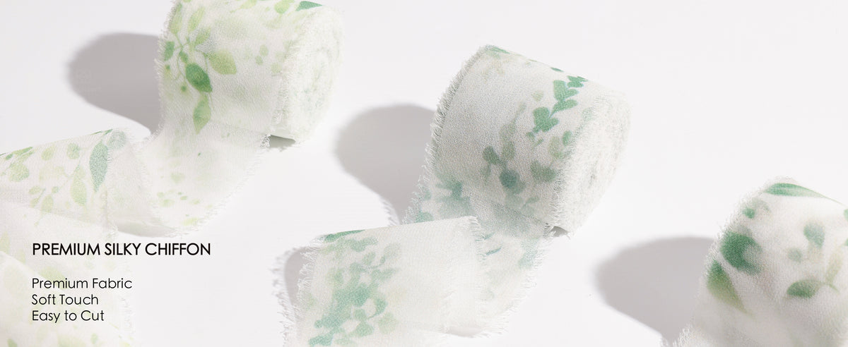 Green leaf-print frayed ribbon wraps a wax-sealed card and adorns a white flower basket