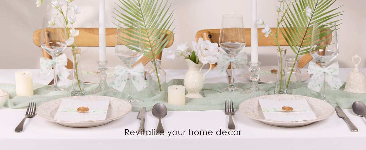 Rolls of sheer white chiffon ribbon with green botanical prints and frayed edges