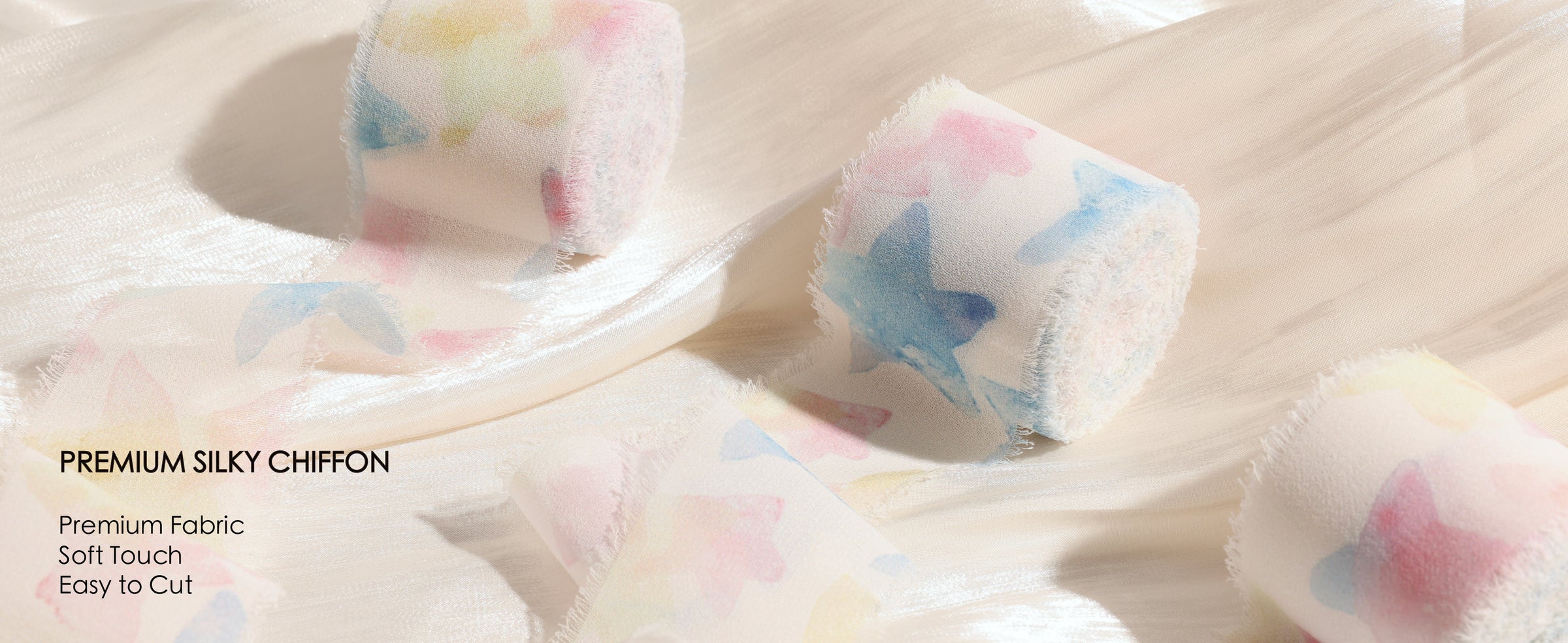 Pastel printed silky chiffon ribbon rolls with sheer fabric and soft frayed edges on cream satin