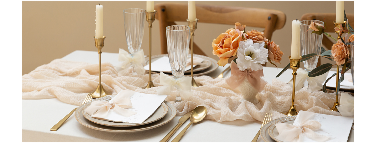 Cream chiffon ribbon bows accent glassware and place cards on an elegant candlelit table