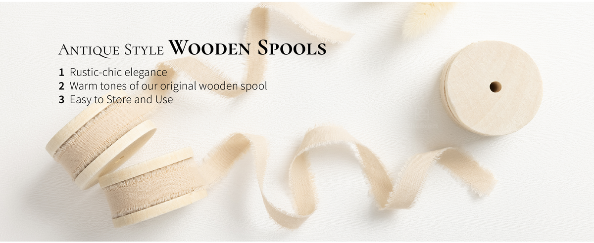 Light nude frayed cotton ribbon wound on pale wooden spools with loose ribbon trails