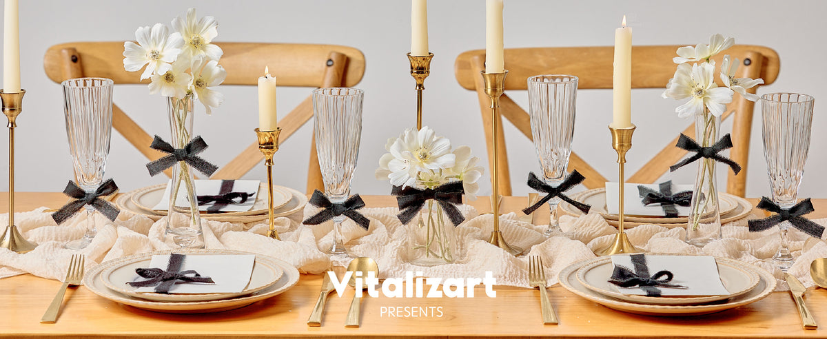 Black frayed ribbon bows decorate flowers, glassware, and place cards on a candlelit dining table