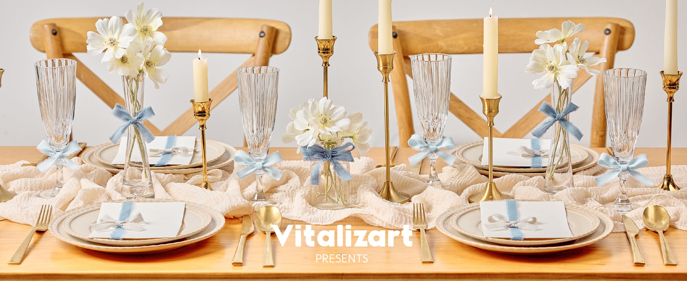 Pale blue fringed cotton ribbon decorates vases, glasses, and place settings on an elegant dining table.