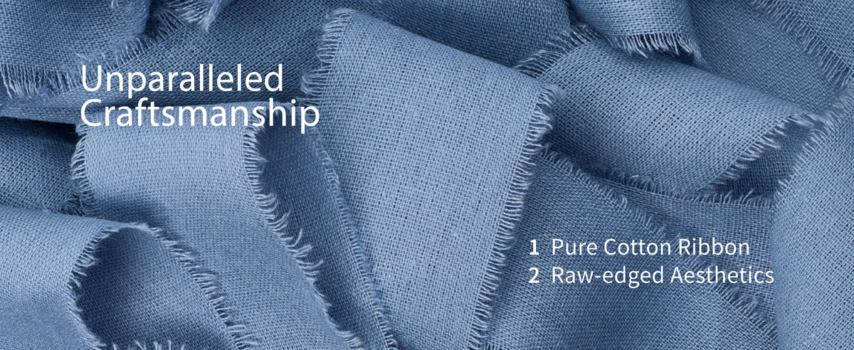 Close-up of dusty blue cotton ribbon with a fine woven texture and softly frayed raw edges.