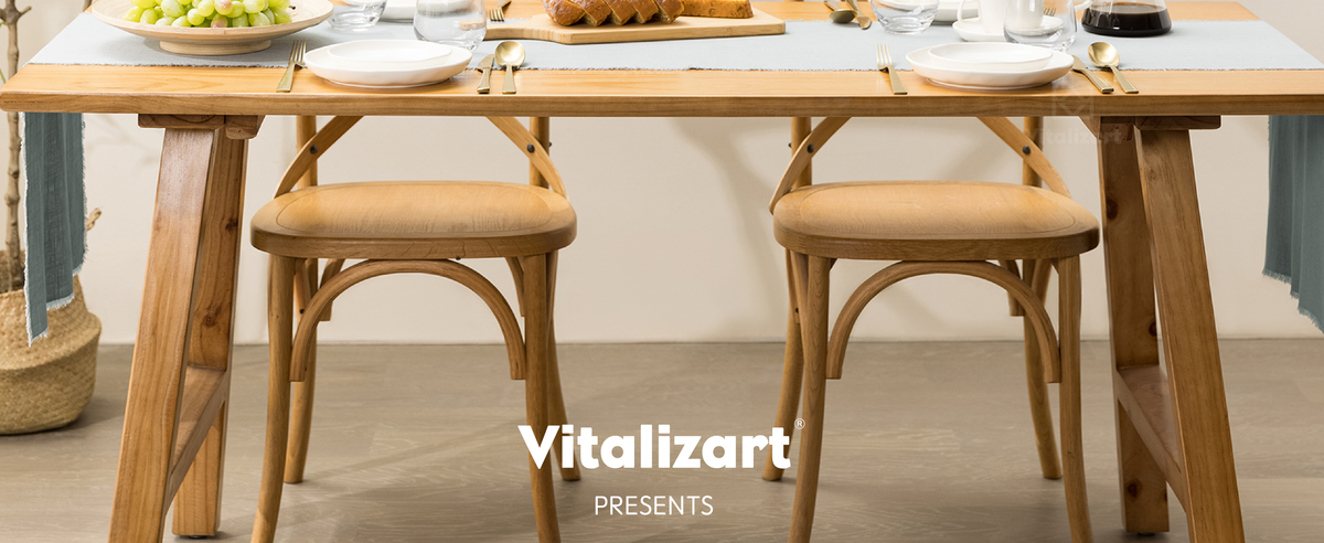 Sage green fringed table runner on a wooden dining table set for two with bread and grapes