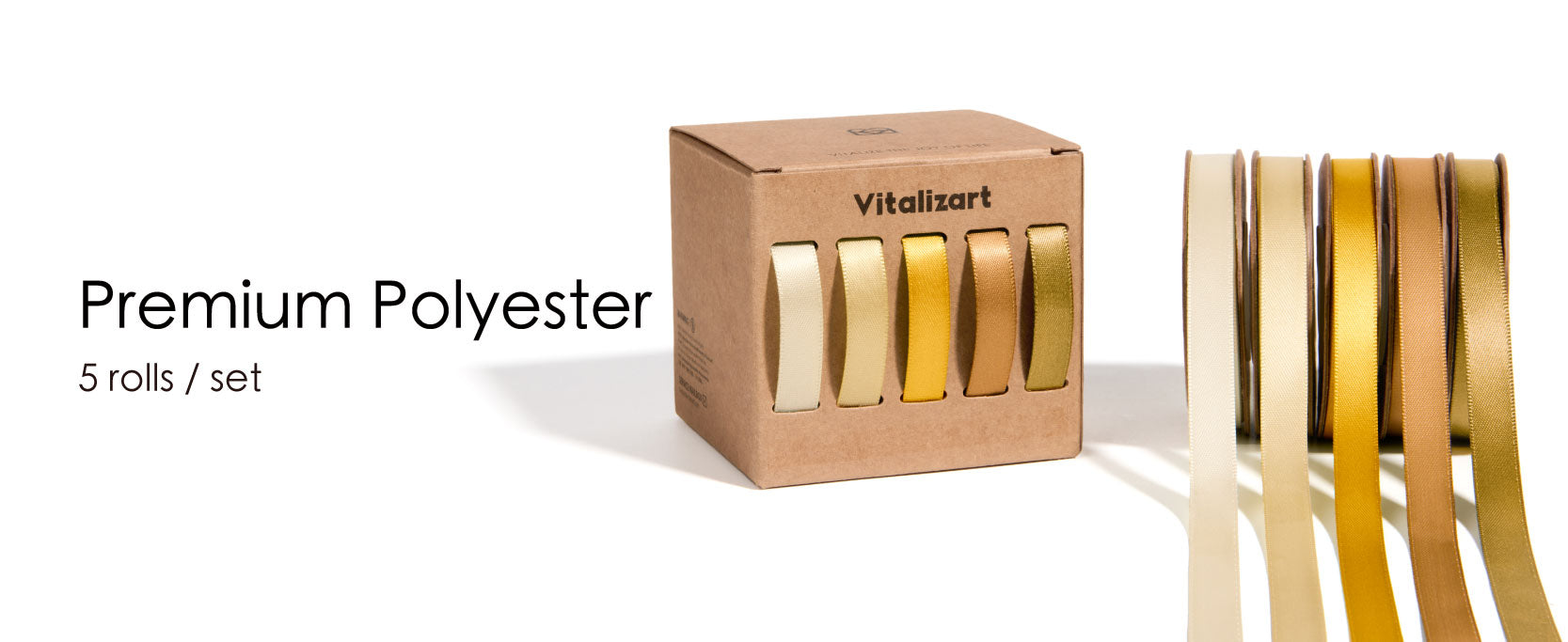 Five cream-to-gold satin ribbon rolls beside a kraft dispenser box, with loose ends hanging forward