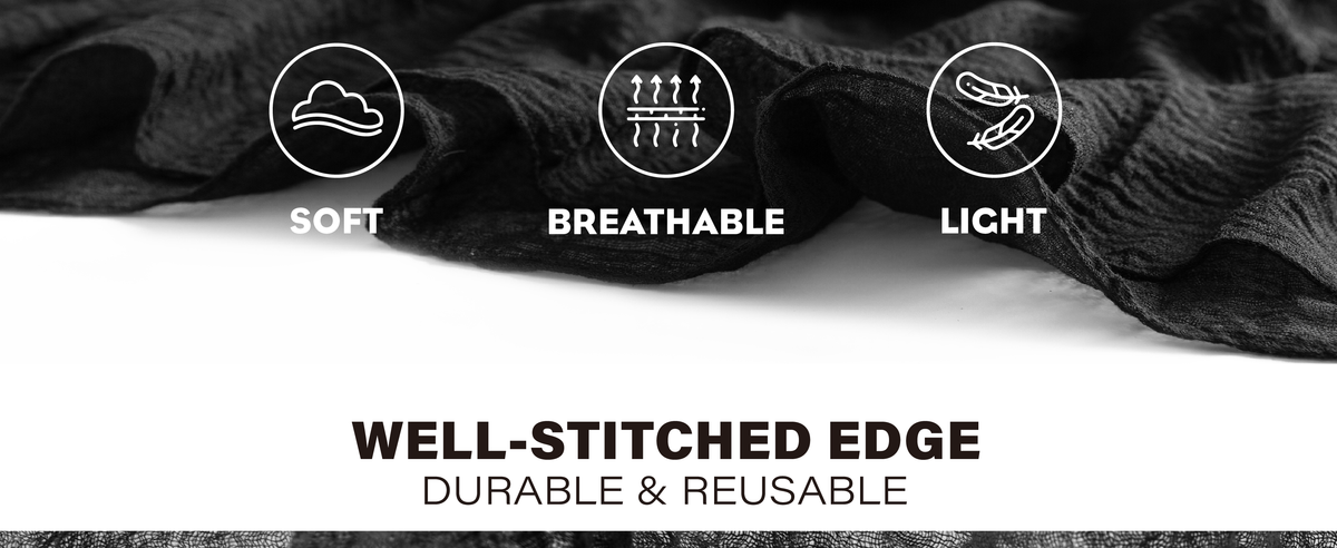 Black cheesecloth table runner draped in loose folds to show its crinkled weave and stitched edge.