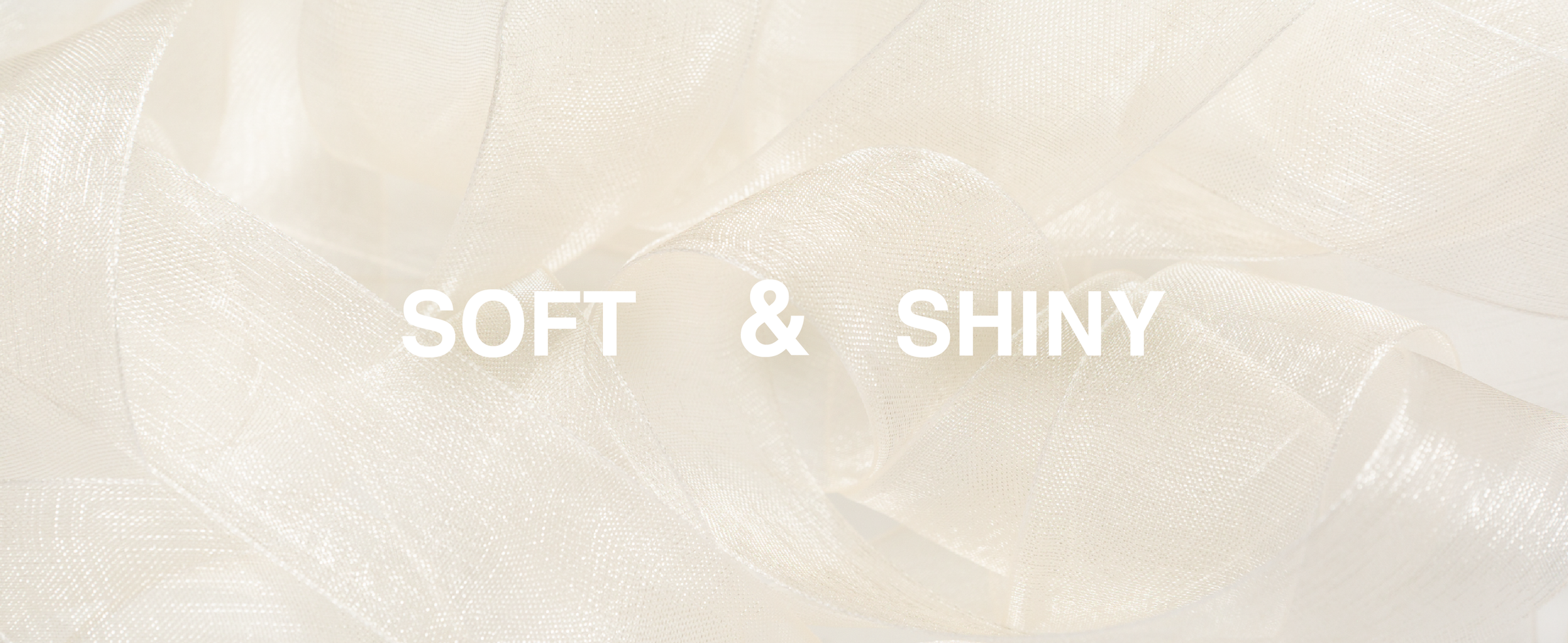 Ivory sheer organza ribbon in loose overlapping loops, highlighting its fine weave and soft sheen.