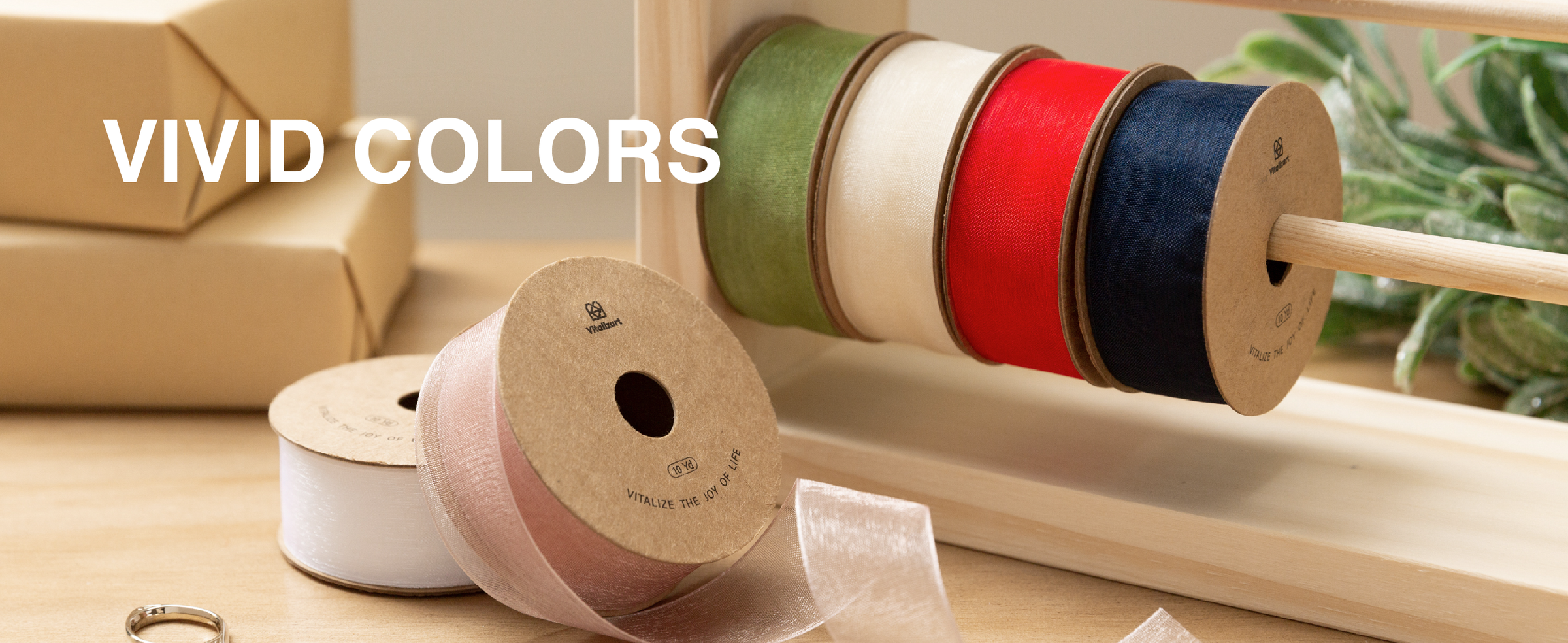Sheer ribbon spools in green, ivory, red, navy, white, and pale pink on a wooden rack
