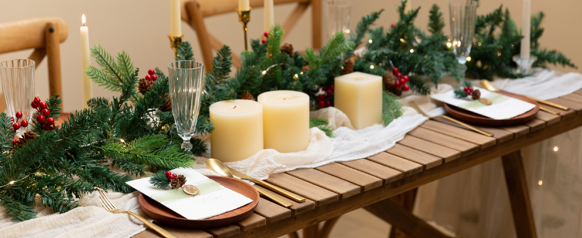 Sage green sheer organza ribbon accents place cards on a candlelit holiday dining table.
