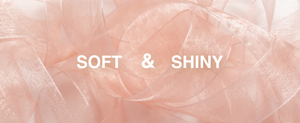 Close-up of soft, shiny blush-pink sheer organza ribbon with translucent woven texture