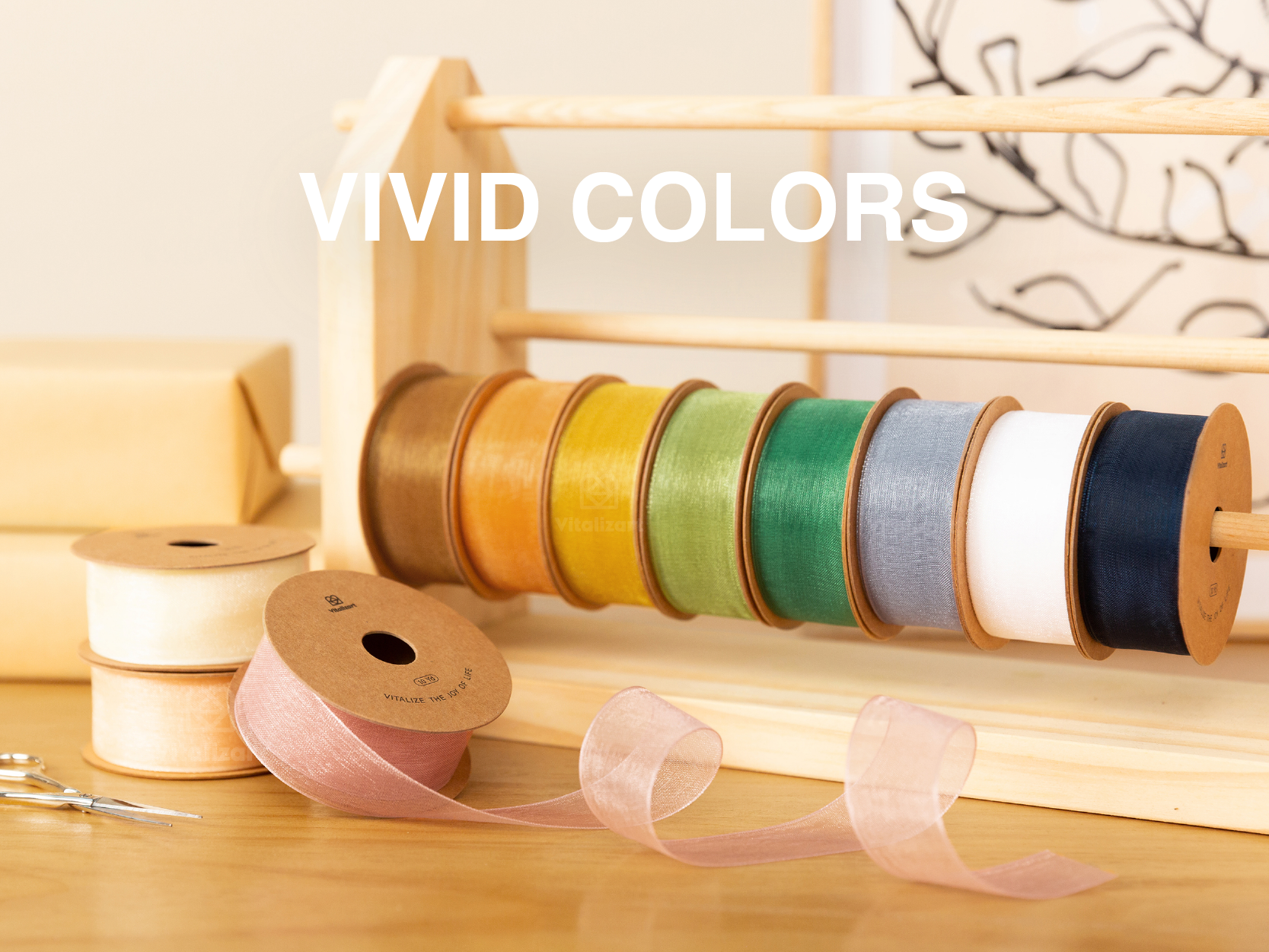 Sheer organza ribbon spools in assorted vivid colors displayed on a wooden rack and craft table