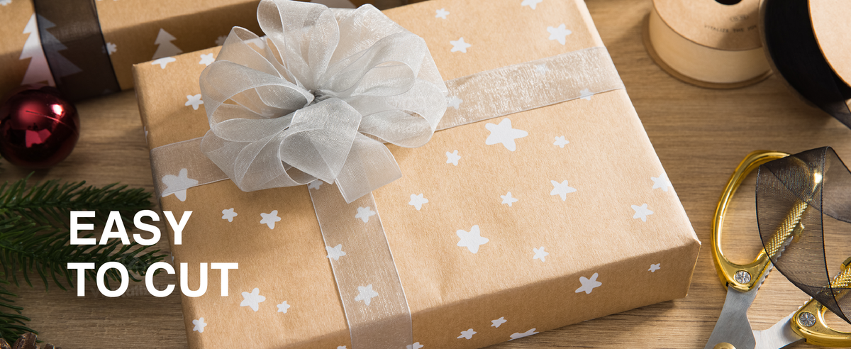 Silver-white organza ribbon tied into a large bow on a star-patterned kraft gift box.