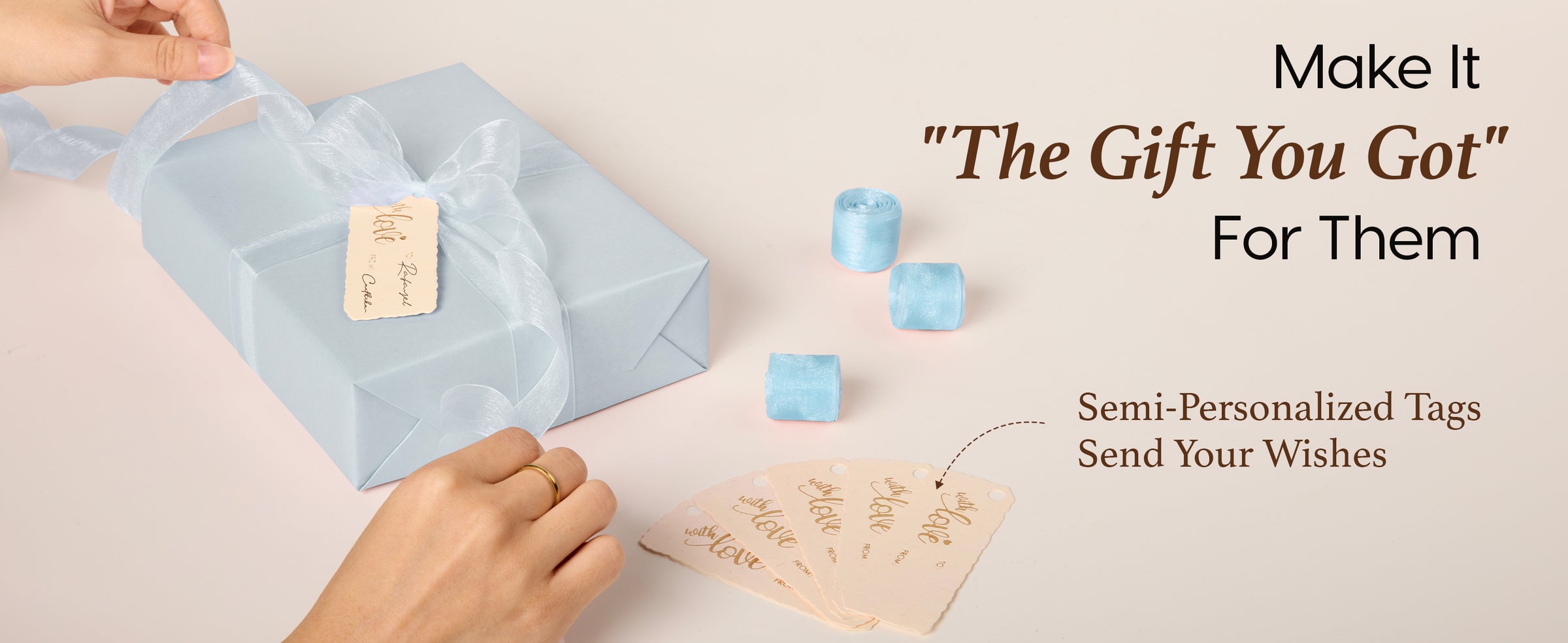 A hand presenting a gift wrapped with the baby blue pearly wrapping paper set and matching accessories