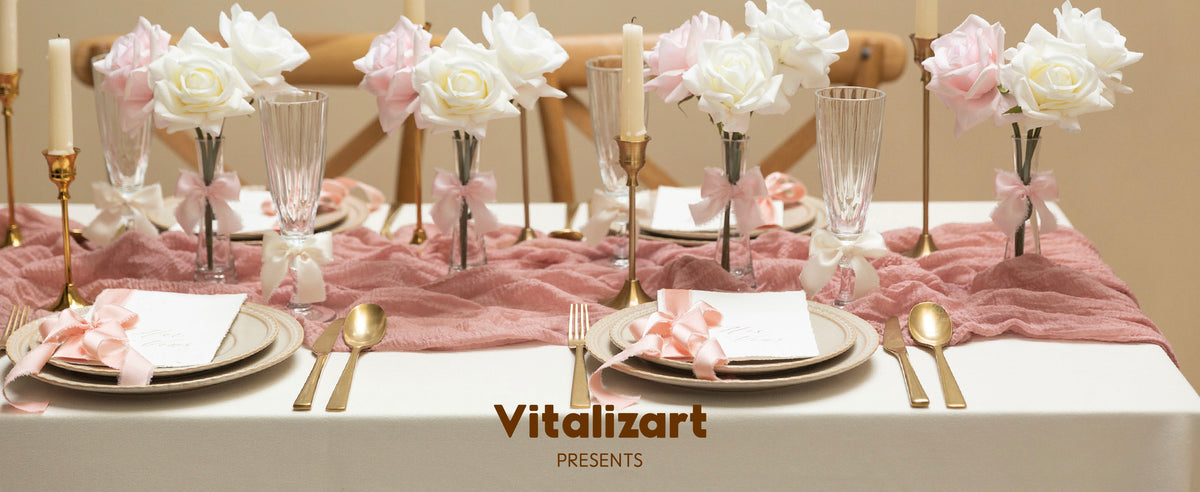 Light pink satin ribbon bows decorate flowers and place cards on an elegant candlelit dining table.
