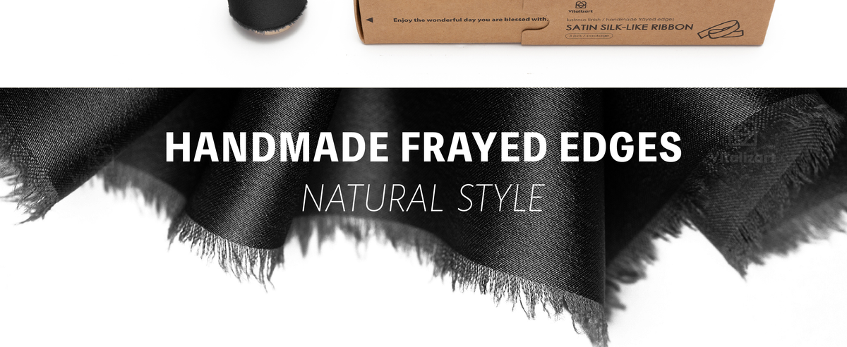 Close-up of black satin ribbon with a glossy woven surface and softly frayed edges
