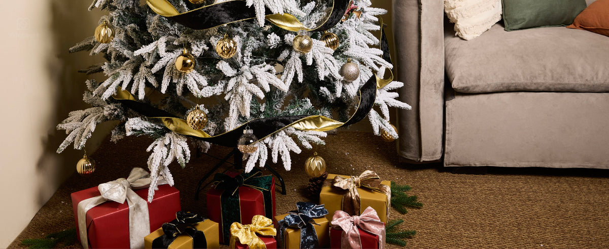 Black velvet ribbon with a gold reverse draped in waves around a flocked Christmas tree